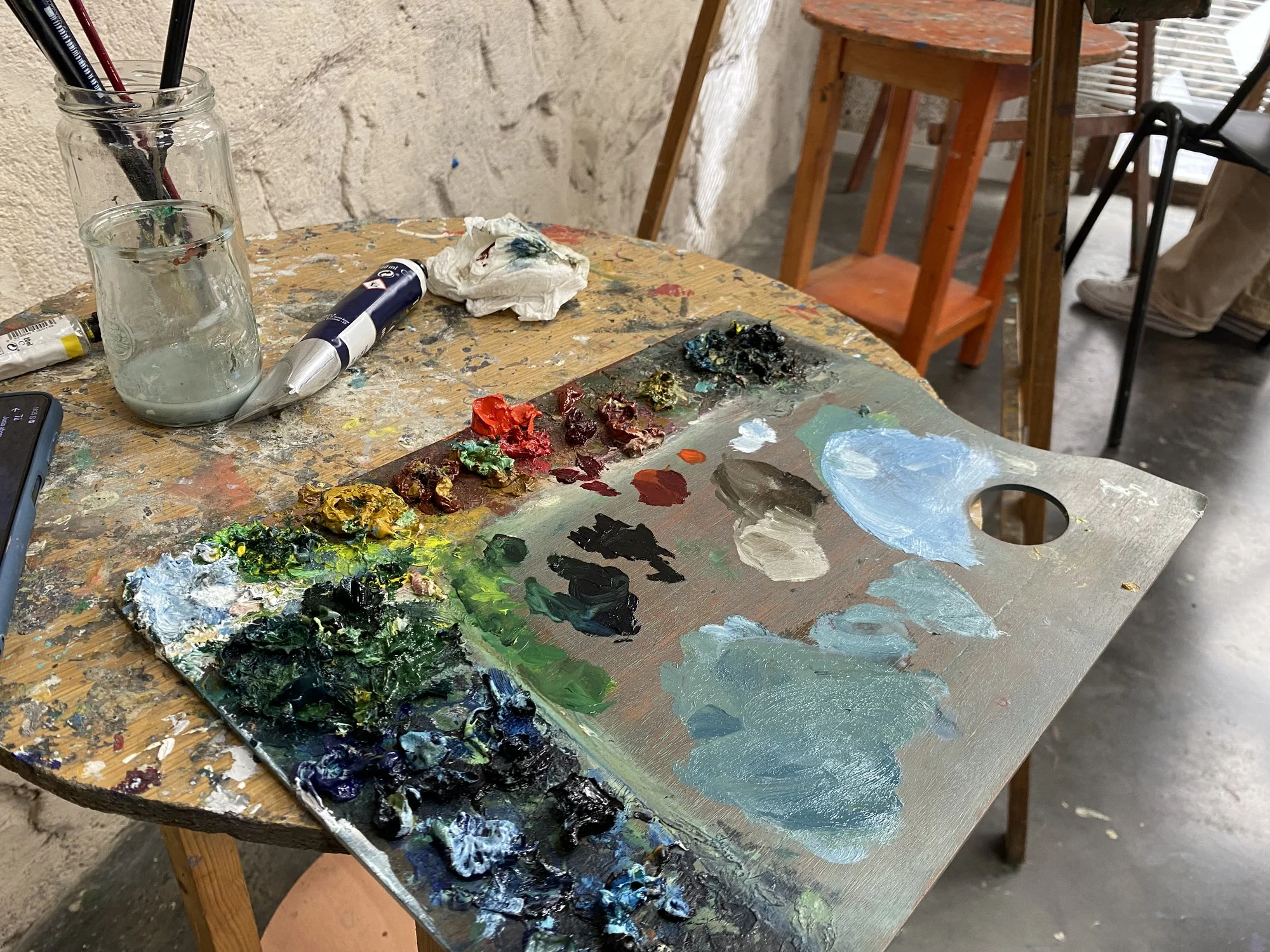 Mesa con pinturas y pinceles, utilizada en los cursos intensivos de dibujo y pintura en Los Remedios, Sevilla.